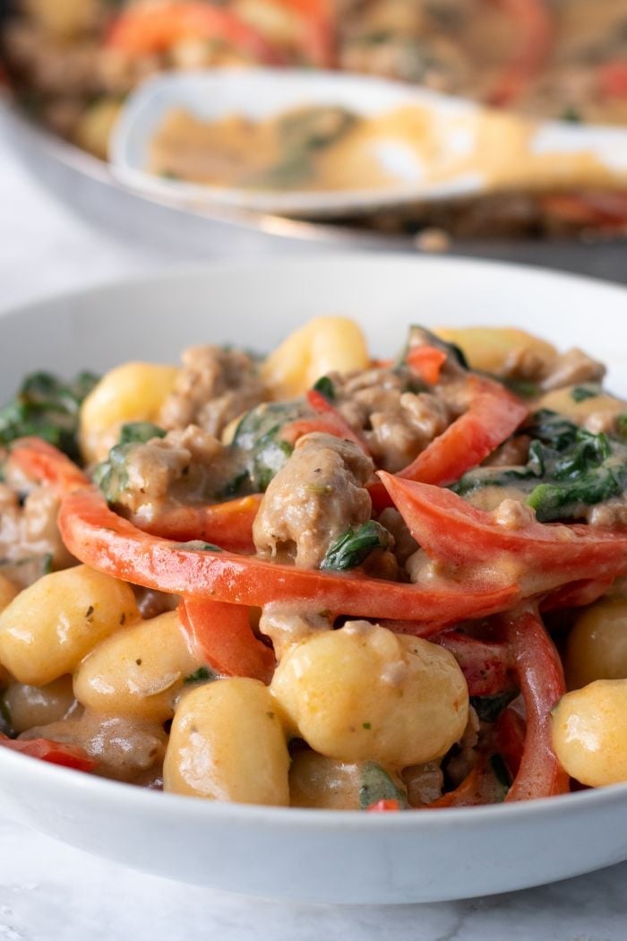 a close up of creamy gnocchi and sausage 